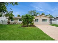 Charming single-story home with a well-manicured lawn, mature landscaping, and a welcoming driveway at 4651 Helena Ne St, St Petersburg, FL 33703