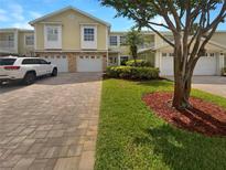 Charming townhome with paver driveway, attached garage, and well-maintained landscaping at 915 Woodbridge Ct, Safety Harbor, FL 34695