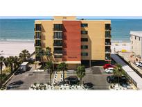 Beachfront condo building with balconies, parking, and palm trees, offering stunning ocean views and easy beach access at 14146 Gulf Blvd # 3A, Madeira Beach, FL 33708