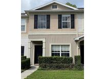 Charming townhome exterior with neutral paint, black shutters and tidy landscaping at 5864 Fishhawk Ridge Dr, Lithia, FL 33547
