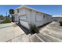 Exterior view of a mobile home with white siding and awnings, surrounded by well-maintained landscaping at 10315 Cortez W Rd # 18D, Bradenton, FL 34210
