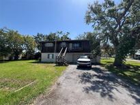 Two-story home with a front-facing garage, complemented by a long driveway and mature trees at 359 S Orchid Dr, Ellenton, FL 34222