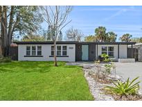 Charming single-story home with a well-maintained lawn, updated landscaping, and a light blue front door at 3926 Helena Ne St, St Petersburg, FL 33703