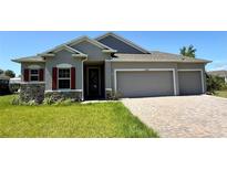Charming single-story home with a three-car garage, stone accents, and a well-manicured lawn at 27206 Adams St, Punta Gorda, FL 33983