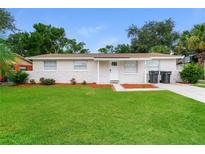 Charming single-story home featuring a well-manicured lawn, stone accents, and a classic white front door at 6426 Eden Ln, Tampa, FL 33634