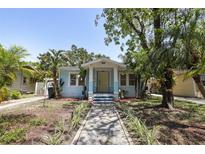 Charming blue bungalow with a stone walkway, mature trees, and a well-manicured front yard at 6503 N Wellington Ave, Tampa, FL 33604