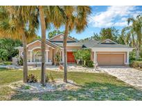 Beautiful single-Gathering home with manicured lawn, lovely landscaping, charming facade, and an attached two-car garage at 14680 Linden Dr, Spring Hill, FL 34609
