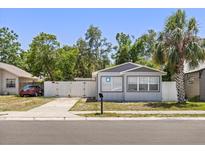 Charming single-story home featuring a white fence and lush green trees at 1465 Pierce St, Clearwater, FL 33755
