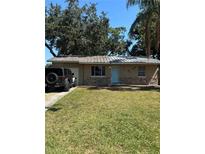 Charming single-story home featuring stone accents, a well-manicured lawn, and a light-blue front door at 1317 W Alicia Ave, Tampa, FL 33604