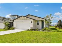 Charming single-story home features a manicured lawn and a two-car garage, complemented by blue skies at 14005 Crutchfield Ct, Parrish, FL 34219