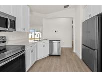 Bright kitchen features stainless steel appliances, white cabinets, and modern countertops, creating a clean and inviting space at 4604 Hunts Ave, Plant City, FL 33566