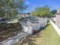 View of backyard and roof, along with a long driveway leading to an attached garage at 4601 Copper Ln, Plant City, FL 33566