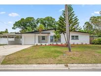 Charming single-story home featuring a lush green lawn and an attached carport at 5629 36Th N Ave, St Petersburg, FL 33710