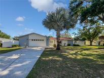 Charming single-story home featuring a spacious front yard, beautiful tree, and an attached two car garage at 6623 Baybrooks Cir, Temple Terrace, FL 33617