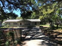 Charming single-story home with a long driveway and beautiful mature trees at 4922 Thonotosassa Rd, Plant City, FL 33565