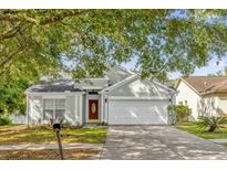 Charming single-story home with a well-manicured lawn, mature trees, and a two-car garage at 7511 Savannah Ln, Tampa, FL 33637
