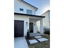Modern two-story home featuring a black garage door and stylish exterior lighting at 2309 S Ardson Pl # 1, Tampa, FL 33629