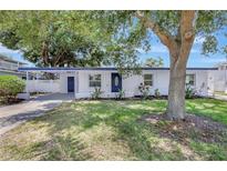 Charming single-story home featuring a well-manicured lawn and beautiful landscaping at 4928 Stolls Ave, Tampa, FL 33615