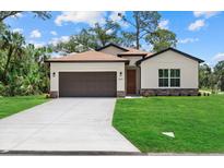 Charming single-Gathering home features a well-manicured lawn, two-car garage, and neutral color scheme at 2682 Edwin Ave, North Port, FL 34288