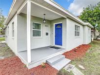 Charming home featuring a bright blue front door and a covered porch at 8231 Riverside Ne Dr, St Petersburg, FL 33702