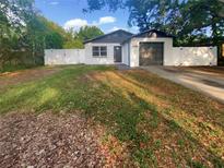 Charming single-story home featuring a freshly painted exterior, dark gray accents, and an attached garage at 1736 Taylor Lake Pl, Largo, FL 33778
