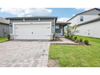 Charming single-Gathering home featuring an attached two-car garage and a beautifully landscaped front yard at 1828 Brekey Way, Zephyrhills, FL 33541