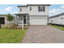 Charming two-story home with a two-car garage and a beautifully paved driveway at 1855 Brekey Way, Zephyrhills, FL 33541