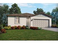 Charming single-story home with neutral stucco, a two-car garage, and colorful landscaping at 31660 Wild Grape Ln, Brooksville, FL 34602