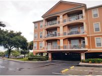 A three-story condo building featuring stucco walls, balconies, and covered parking at 5000 Culbreath Key Way # 9-101, Tampa, FL 33611