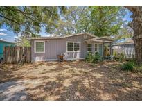 Charming single-story home featuring a well-maintained facade, a gravel yard and mature trees at 9307 N Oakleaf Ave, Tampa, FL 33612