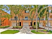 Inviting townhouse exterior with a white fenced balcony, a one car garage and neat landscaping at 5016 W Lancaster St # 00, Tampa, FL 33616