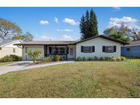 Charming single-story home with well-maintained lawn and inviting front porch at 1073 Kenwood Dr, Dunedin, FL 34698