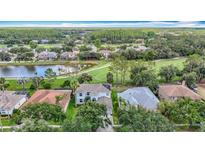 Expansive aerial view showcasing the home's location on a golf course with water views and lush landscaping at 18109 Kara Ct, Tampa, FL 33647