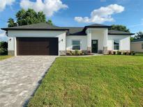 Charming home with a well-manicured lawn, a paved driveway, and a two-car garage at 1732 Rada Ln, North Port, FL 34288