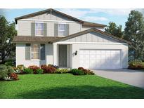 Charming two-story home featuring white stucco, sage shutters, manicured lawn, and an attached two-car garage at 1740 Brekey Way, Zephyrhills, FL 33541