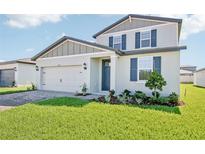 Charming two-story home with a manicured lawn, brick driveway, and blue shutters at 1740 Brekey Way, Zephyrhills, FL 33541