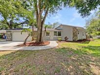 Charming single-story home with stone accents, mature trees, and landscaped front yard at 5225 20Th N St, St Petersburg, FL 33714