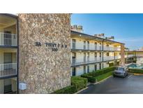 Condo complex exterior with stone facade, balcony, and well-maintained landscaping at 6100 12Th S St # 313, St Petersburg, FL 33705