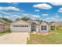 Charming single-story home featuring an attached two-car garage and neutral-toned stucco exterior at 22802 Roderick Dr, Land O Lakes, FL 34639