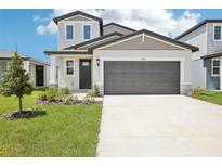 Charming two-story home featuring a modern exterior, well-manicured lawn, and a spacious driveway with an attached garage at 3550 Moscato Dr, Brooksville, FL 34602