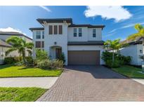 Beautiful two-story home with a brick driveway, well-manicured lawn, and a two-car garage at 4861 Antrim Dr, Sarasota, FL 34240