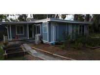 Quaint home featuring blue siding, lattice accents, and a charming garden bed, perfect for relaxed outdoor living at 6505 Oelsner St, New Port Richey, FL 34652