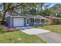 Charming single-story home with a well-manicured lawn, covered porch and a one car garage at 7214 Oakwood Dr, New Port Richey, FL 34652