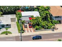 Beautiful home featuring lush tropical landscaping, a brick driveway, and a detached garage at 16107 Gulf Blvd, Redington Beach, FL 33708