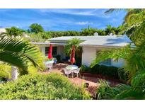 Inviting brick patio with lush landscaping and outdoor seating, perfect for relaxing or entertaining at 16107 Gulf Blvd, Redington Beach, FL 33708