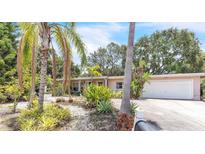 Charming home featuring lush tropical landscaping and a well-maintained two-car garage at 251 Tropic W Blvd, Largo, FL 33770
