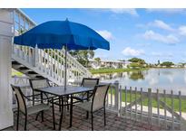 Outdoor patio with table and chairs overlooks a serene lake at 265 Seahorse Se Dr # B, St Petersburg, FL 33705
