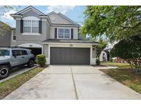 Two-story townhome featuring a two car garage and neutral paint, complemented by a well-manicured lawn at 10124 Westpark Preserve Blvd, Tampa, FL 33625