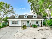 Charming single-story home with light turquoise shutters and light-colored gravel landscaping at 135 Florida Blvd, Crystal Beach, FL 34681
