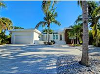 Modern home with lush landscaping, a paver driveway, and a two-car garage on a sunny day at 2408 Nassau St, Sarasota, FL 34231